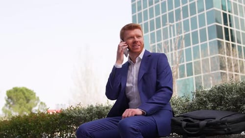 Businessman Talking on Phone Outside Office Building