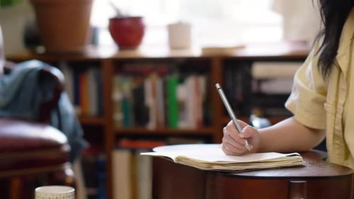 Young Woman Writing in Notebook at Home