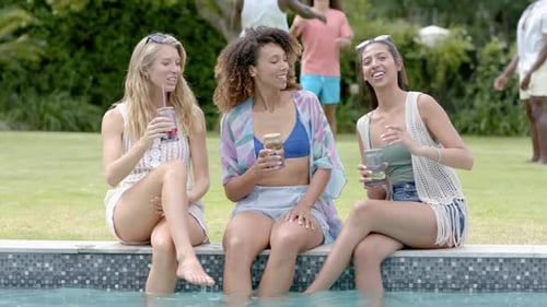 Young Women Toasting Drinks at Poolside Party