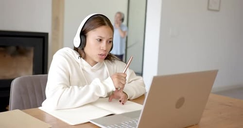 Young Adult Attends Online Class with Laptop