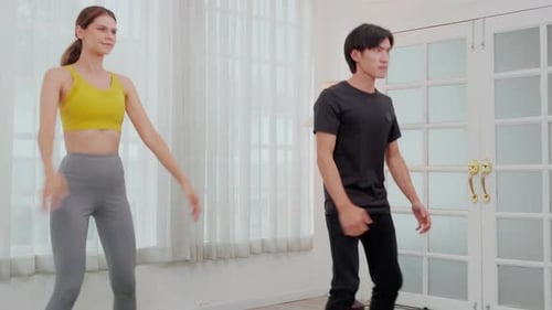 Woman and Man Doing Squats Indoors