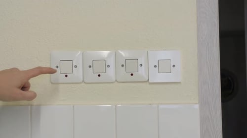 Hand Switches Lights Off on Wall Switches