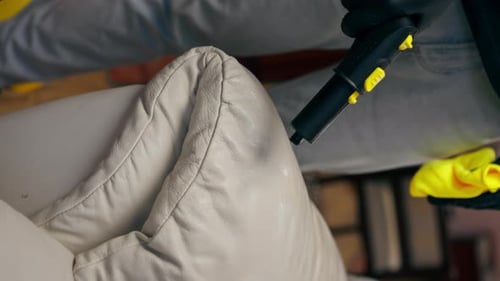 Vertical Video Professional Cleaning Close Up in an Apartment Cleaner Wets a Textile Sofa Before