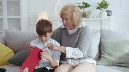 Grandmother and Grandson Using a Tablet on the Couch