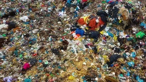 Drone view moving above garbage dump with tone of plastic.