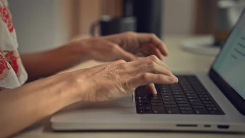 Hands of Woman Typing on Keyboard of Laptop Computer and Working in Home Office