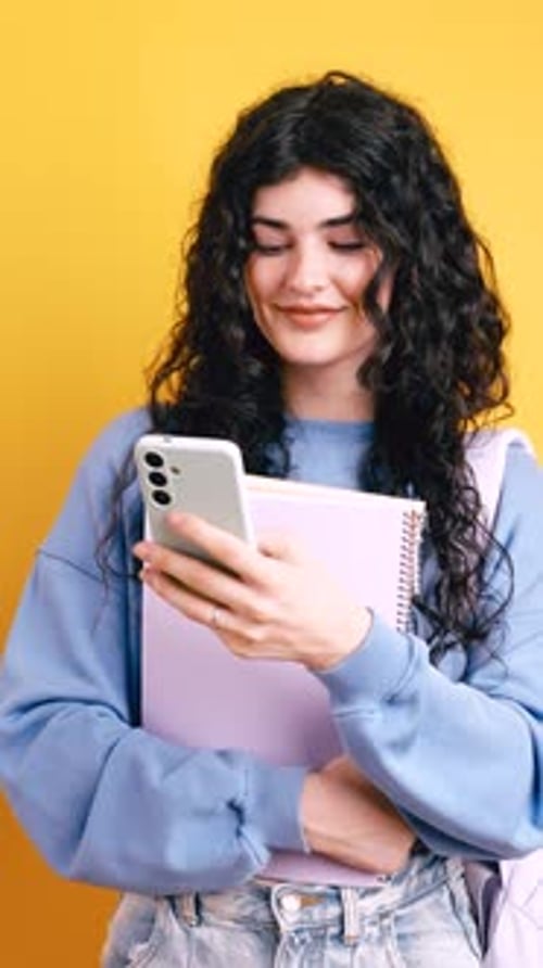 Woman Using Phone and Holding Notebook in Studio