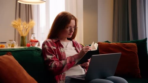 Woman with Laptop and Notebook at Home