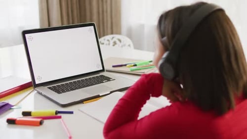 Child Studies with Laptop and Headphones at Home