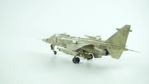 Scale Model Of Jaguar Airplane With Desert Camouflage On White Background.