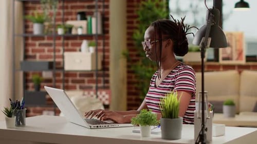 Woman Working at Laptop in Bright Home Office
