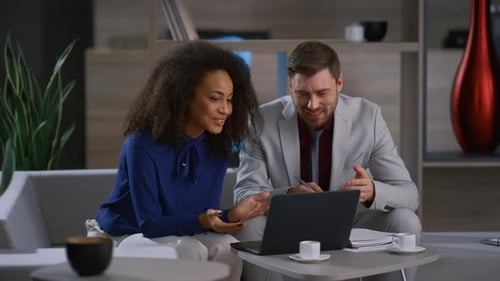 Business Colleagues Discussing Laptop, Smiling in Modern Office