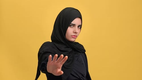 Young Turkish Woman in Black Hijab Shaking Hand Stop Not Gesture Posing Isolated on Orange Studio