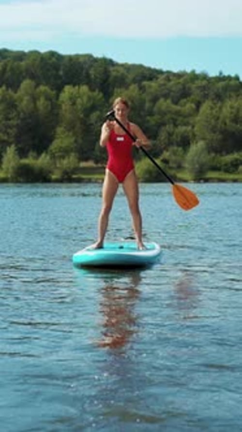 Enjoy the Thrill of Summer Fun with a Paddleboarding Adventure on the Serene Lake