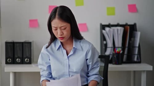 Frustrated Woman Throwing Paper at Workplace