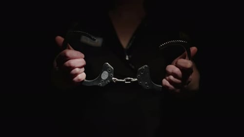 Policeman closes handcuffs holding in his hands