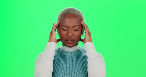 Headache, black woman or pain on green screen for stress, mental health fatigue or sick in studio