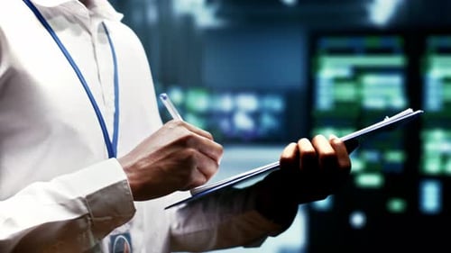 Adult Writes on Clipboard in Server Room