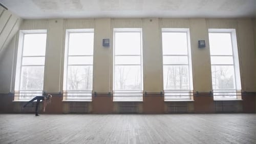 Young Woman Performs Acrobatic Moves in Bright Room