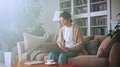 Woman Using Laptop Computer While Sitting on Couch
