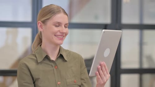 Young Woman on Tablet Video Call in Office