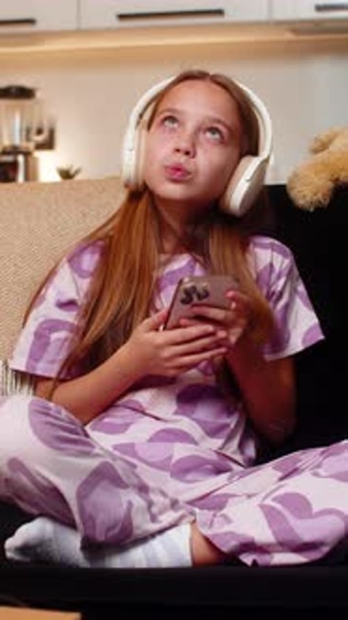 Girl Sits, Listens to Music, Uses Phone at Home