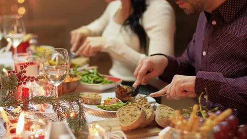 Adults enjoying festive meal at candlelit dinner table