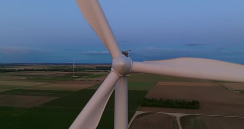 Wind Turbine Turning in a Sunset Sky Generating Green Energy Closeup