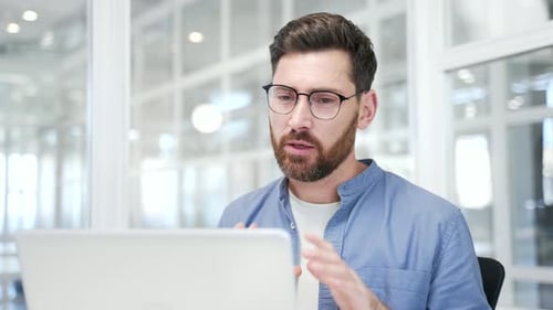 Enthusiastic Man Video Conferencing in Modern Office