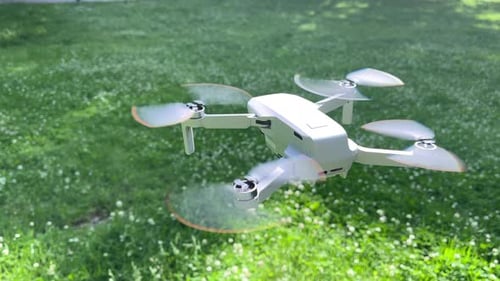 Amazing Closeup Shot of Drone Hovering in Windy Green Park in Daylight Sunlight Sunrays
