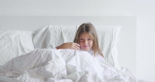 Girl Wakes and Stretches in White Bed