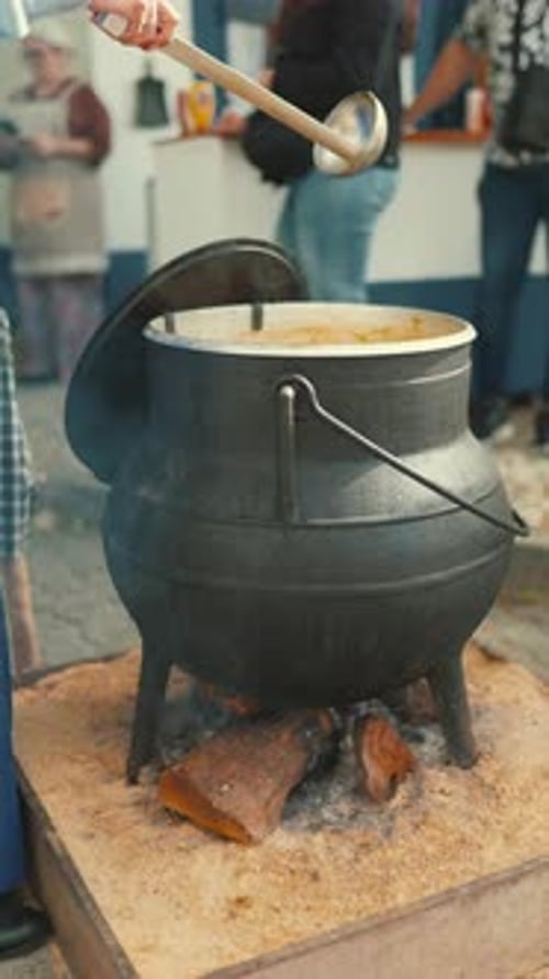 Les gens se rassemblent autour d'une grande marmite pour cuisiner des aliments