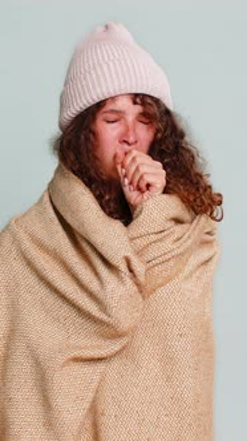 Ill young woman wrapped in a blanket