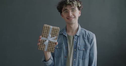 Smiling Young Adult Offers Gift