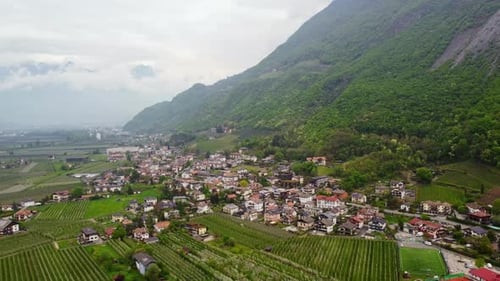 Aerial drone view of a small italian village in verdant countryside scenery at the foot of the mount