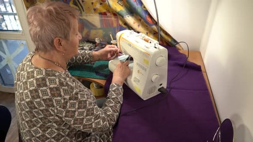 Woman Sewing with a Machine at Home Indoors