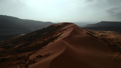 Aerial View of Desert Sand Dunes and Mountains