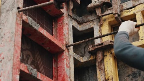 Worker Inserting Formwork Tie Rod Through Wall Formwork Panels