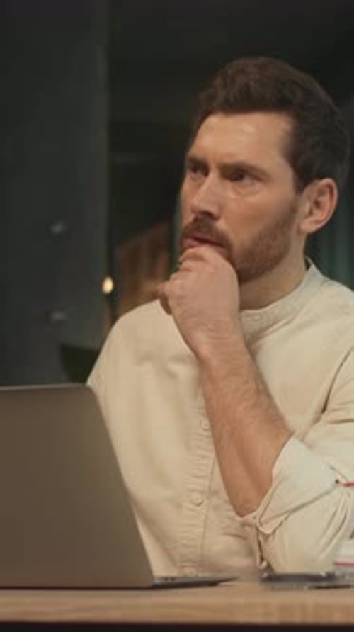 Focused Man Working on Laptop in an Office