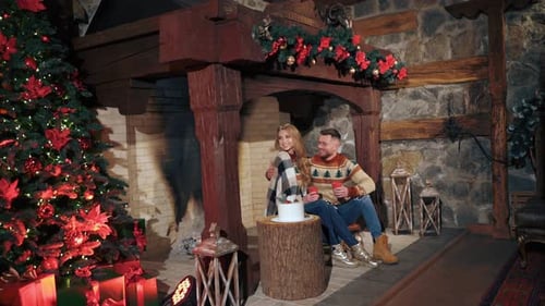 Romantic Couple Celebrating Christmas by Cozy Fireplace