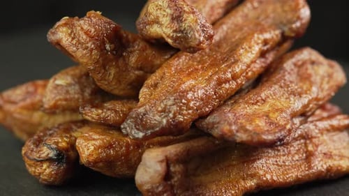 Pile of Dried Bananas on Dark Surface
