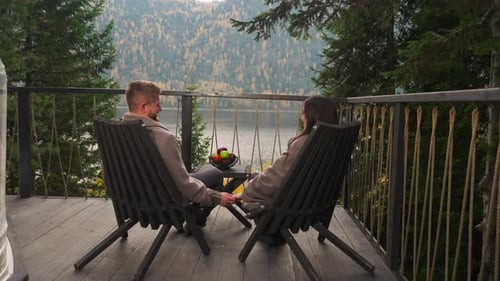 Couple Smiles with Hands Entwined on Terrace