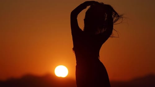 Woman Silhouette Dancing at Sunset