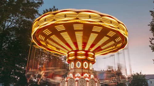 Brightly Illuminated Rotating High Speed Carousel MerryGoRound Summer Evening Night In City