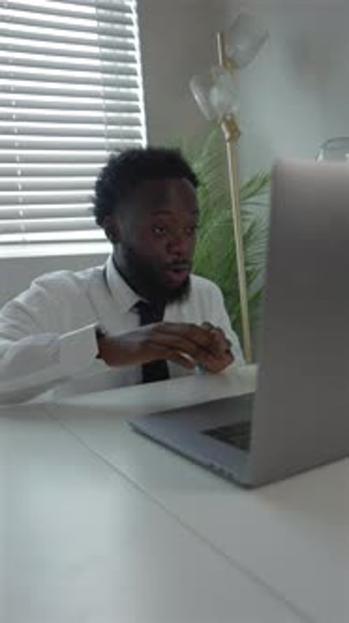 Vertical Video Black Male Remote Worker In Tense Video Call At Home Office