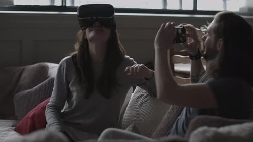 Woman uses VR Headset while man takes photo