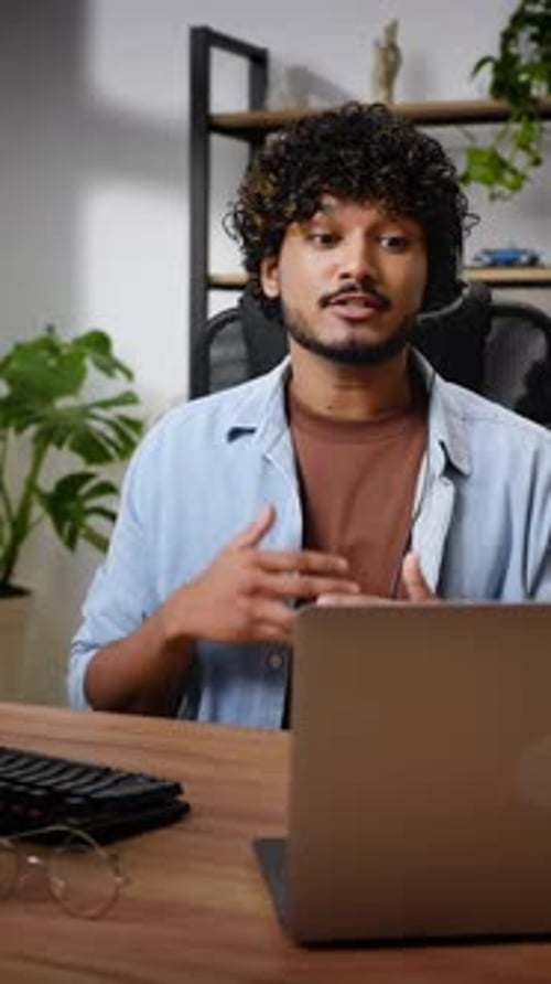 Young Man Video Conferencing at Desk with Laptop