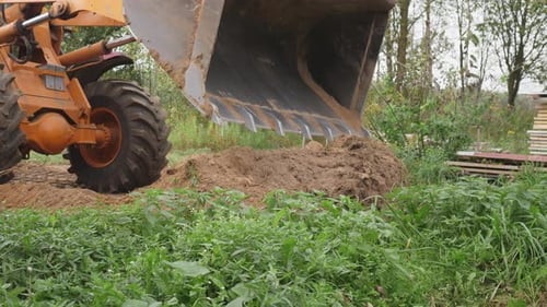 Tractor Loader Moving Dirt in Rural Field