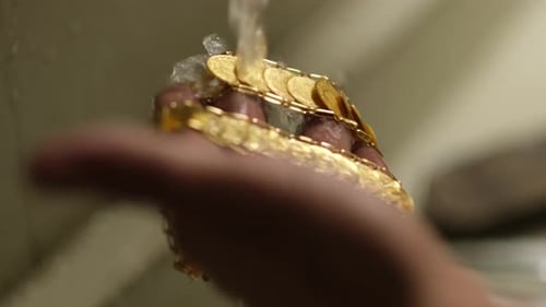 Goldsmith Rinsing Gold Jewelry Under Running Water