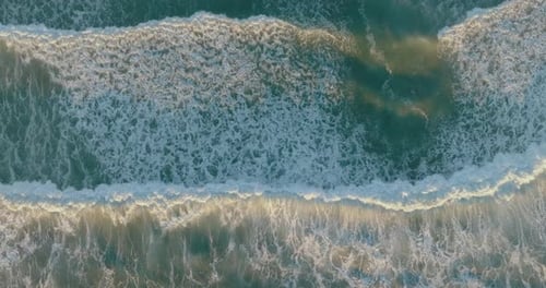 Aerial view of drone flying above beautiful beach with views of ocean waves